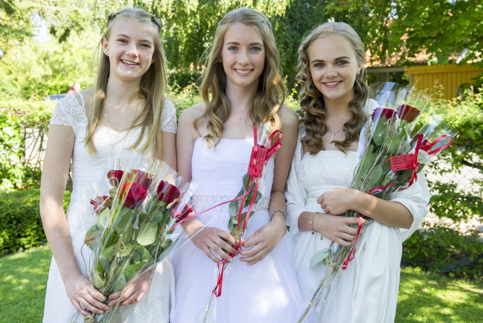 Festfotograferne har her fotograferet 3 kvindelige konfirmander med roser i hånden