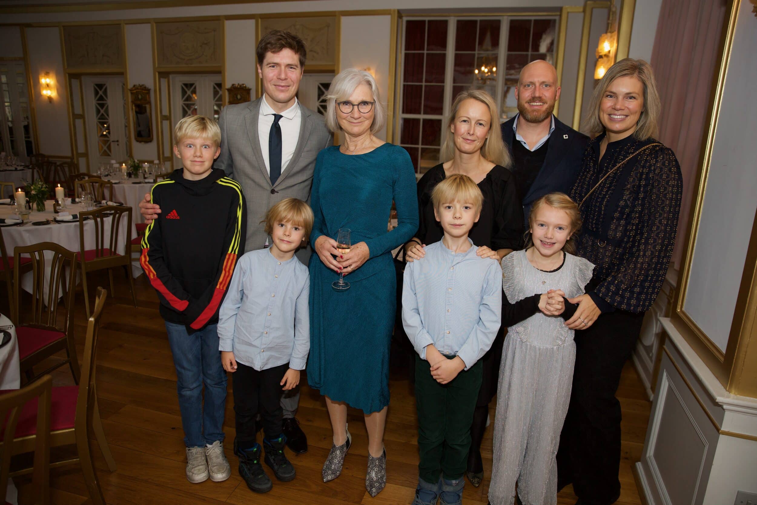 Festfotografen har her fotograferet ved en fødselsdag. På billedet ses en familie på 9 personer opstillet med de voksne bagerst og børnene forrest