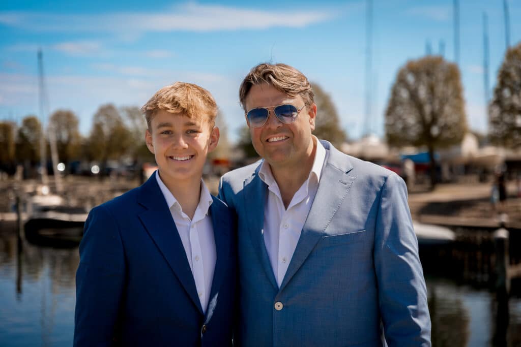 konfirmationsfotografen har her fotograferet Konfirmand Og Far, med sløret blå himmel i baggrunden